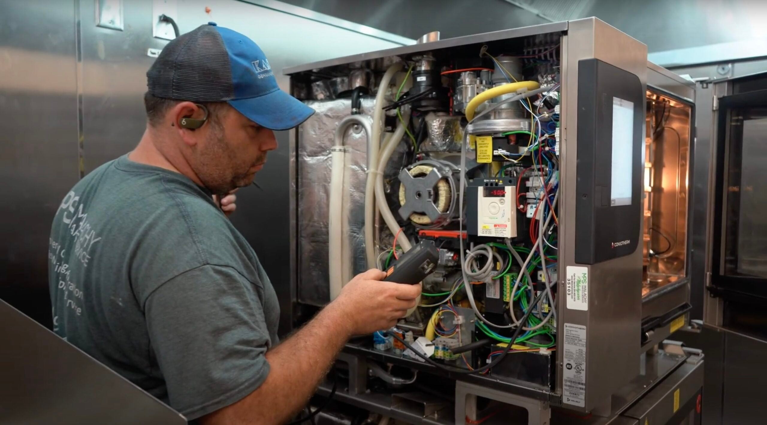 Technician diagnosing commercial kitchen equipment